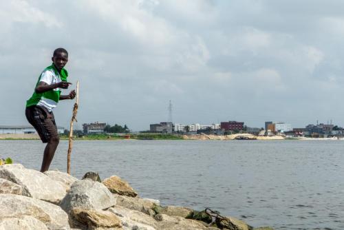 [Non sélectionnée] Un garçon pêche et joue au bord de la lagune