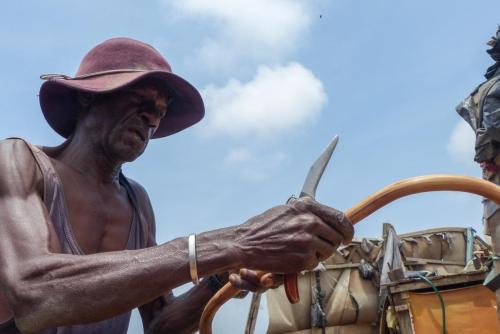 Artisan dans l'atelier d'artisans à ciel ouvert de Zone 3, en bordure de la lagune